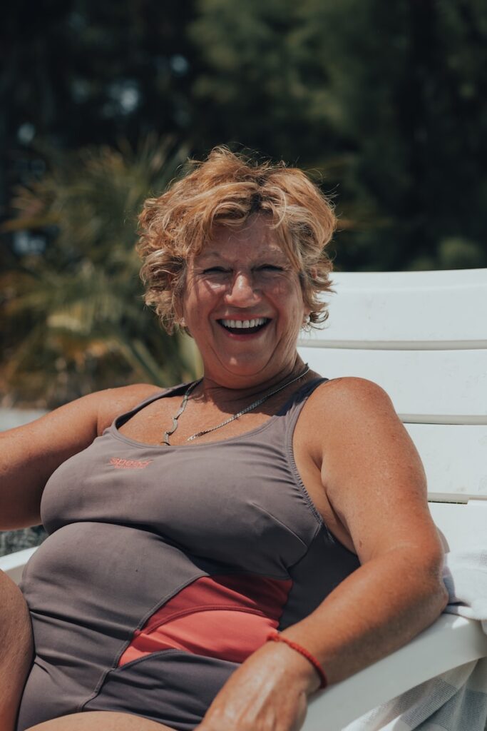 a woman sitting on a white bench smiling