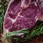 raw meat and green leaf plant on brown surface