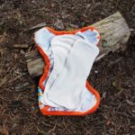 an orange and white cloth on a piece of wood